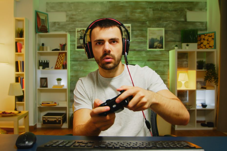 Young adult playing a video game with a controller.